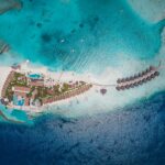 Aerial view of a tropical island resort and turquoise ocean.