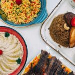 Colorful Middle Eastern dishes including rice, hummus, and grilled meats, perfect for food lovers.