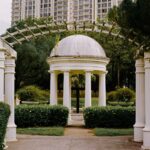 Beautiful white gazebo with pillars in a lush Malaysian garden. Perfect for serene moments.