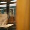 Classic wooden bench inside a vintage train with view of adjacent carriage.