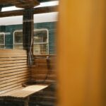 Classic wooden bench inside a vintage train with view of adjacent carriage.