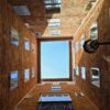 View of blue sky framed by brick courtyard with historic architecture