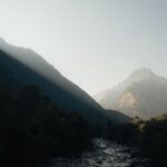 Captivating view of Ticino's mountainous landscape with sunlight streaming through the peaks.