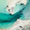 Stunning aerial photograph of Elafonissi Beach, showcasing turquoise waters, sandy shores, and sun umbrellas.