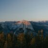 Half dome mountain at sunset with pine trees.