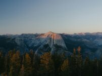 Half dome mountain at sunset with pine trees.