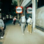 People walk past a darty store on a city street.