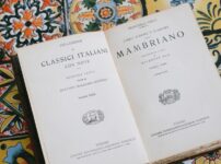 Vintage italian book open on a vibrant tiled table