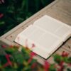 Open book on wooden surface surrounded by flowers
